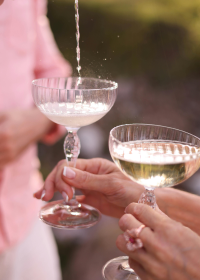 Drinks being poured into cocktail glasses during a social gathering