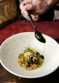 Chef preparing a signature dish with fresh ingredients in hotel restaurant
