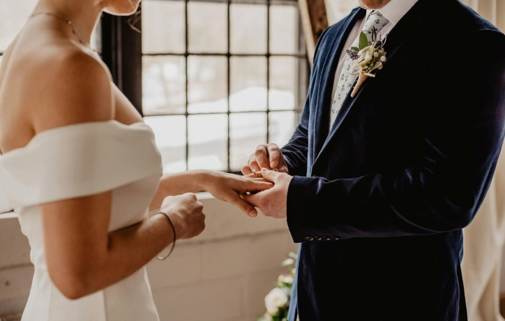 A newlywed couple exchanging wedding rings at the Shelborne Hotel, capturing a beautiful and romantic moment.